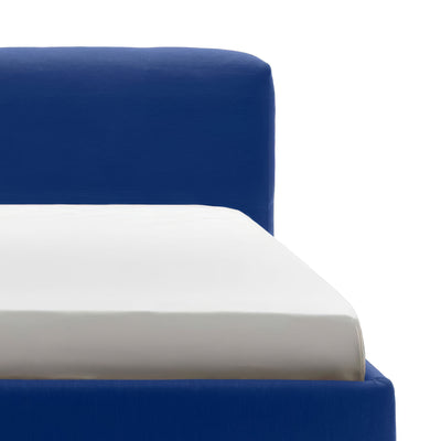 Cappellini Oblong Plus Bed by Jasper Morrison. A blue upholstered bed frame with white and gray layered bedding visible.