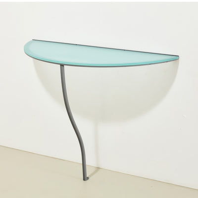 Cappellini One Legged Table by Jasper Morrison. A curved glass-topped console table with a sleek gray metal leg.