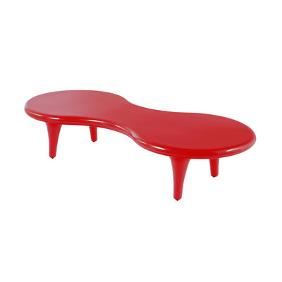 Cappellini Orgone Table by Marc Newson. A glossy red curved table with four tapered legs sits on a white background.