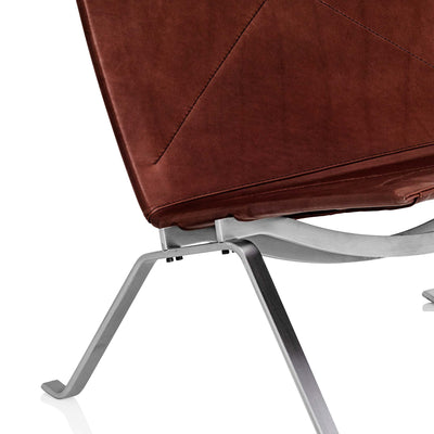 Fritz Hansen PK22™ Lounge Chair by Poul Kjaerholm. Brown leather seat with curved metal frame legs.