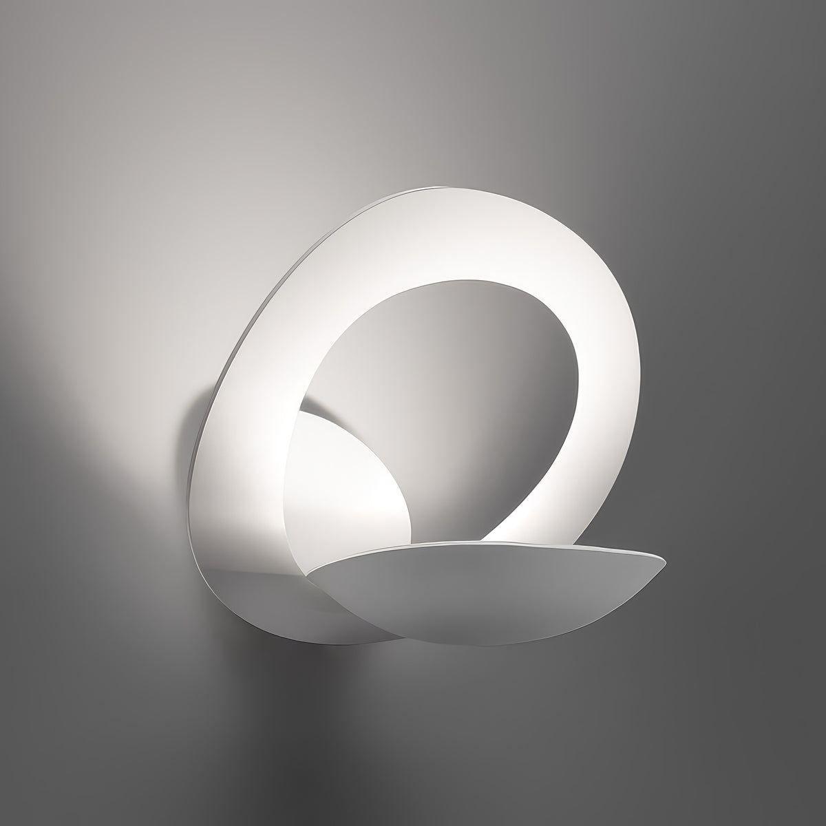 Artemide Pirce Parete by Giuseppe Maurizio Scutellà. A sleek white sculptural form with curved surfaces casts soft shadows.