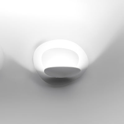 Artemide Pirce Parete by Giuseppe Maurizio Scutellà. A sleek white wall sconce with curved design casts soft light.