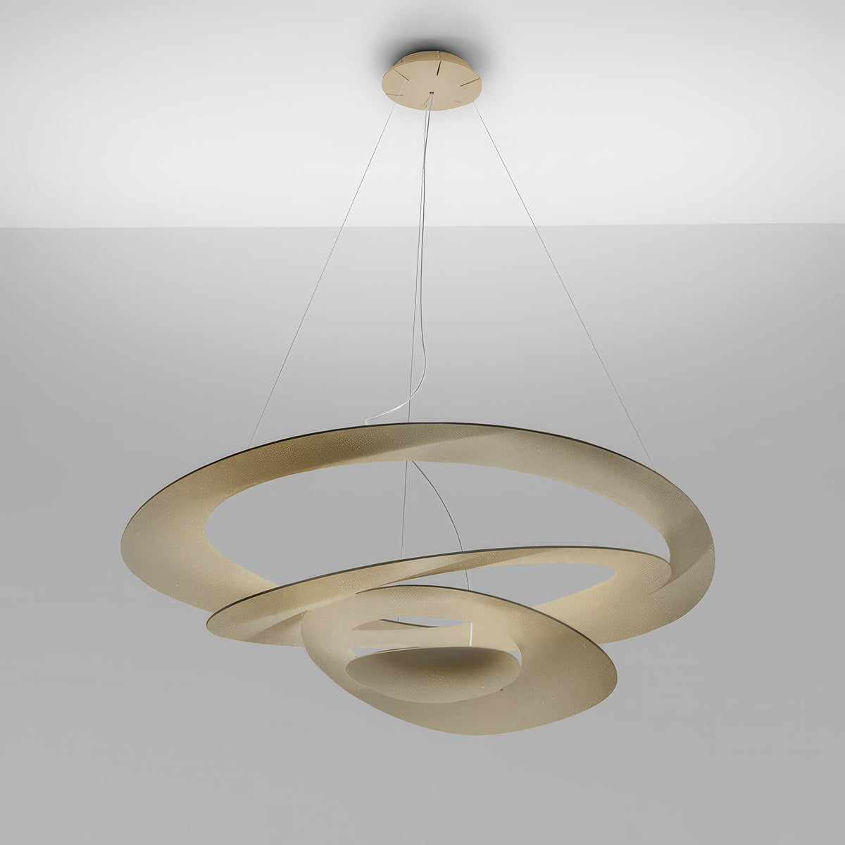 Artemide Pirce by Giuseppe Maurizio Scutellà. Cream-colored spiral rings hang suspended from ceiling in modern interior.