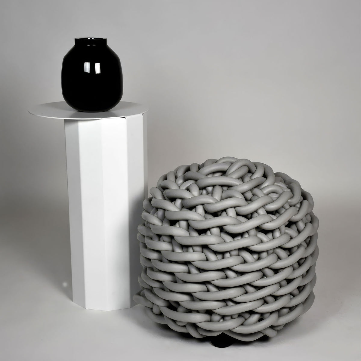 COVO Rebels 1 Pouf by Rosanna Contadini. A glossy black sphere sits atop a white cylinder beside a gray woven orb.