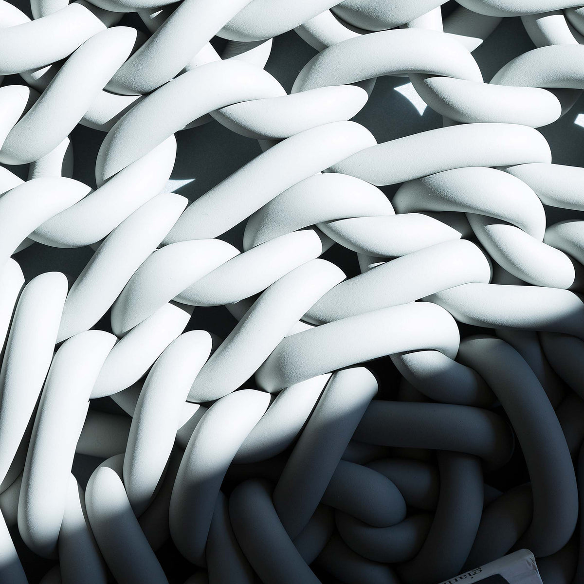 COVO Rebels 1 Pouf by Rosanna Contadini. White and dark twisted cylindrical forms create a dynamic three-dimensional pattern.