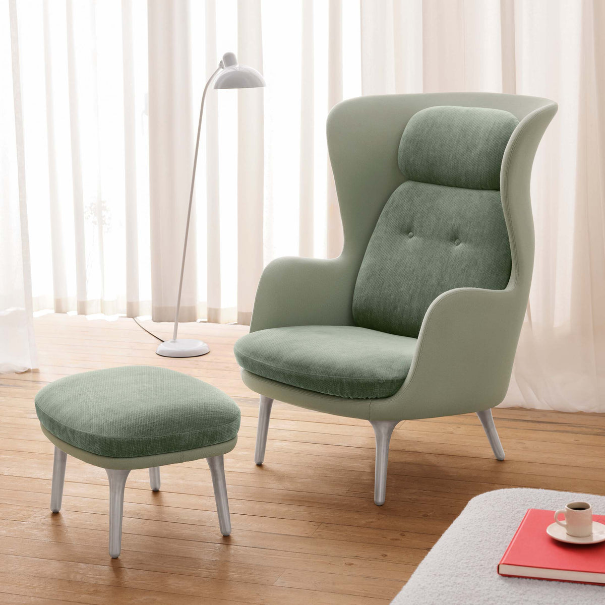 Fritz Hansen Ro™ JH1 Mixed Upholstery by Jaime Hayon. A sage green armchair with ottoman sits in a bright, minimalist room.