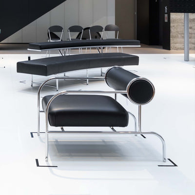 Cappellini Sofa with Arms by Shiro Kuramata. Black leather seating with chrome metal frames in a modern minimalist space.
