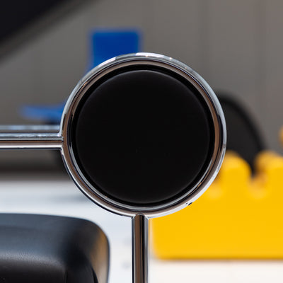 Cappellini Sofa with Arms by Shiro Kuramata. A chrome-rimmed circular mirror reflects dark liquid in a bright workspace.