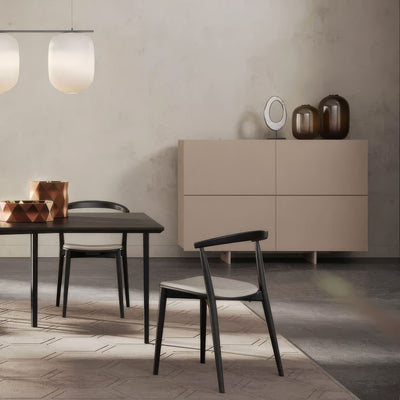 Cappellini Uni Notte by Piero Lissoni. A minimalist dining space features black furniture and warm neutral tones.