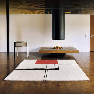 ClassiCon Wendingen Rug by Eileen Gray. Minimalist interior with geometric rug, fireplace, and modern furniture.