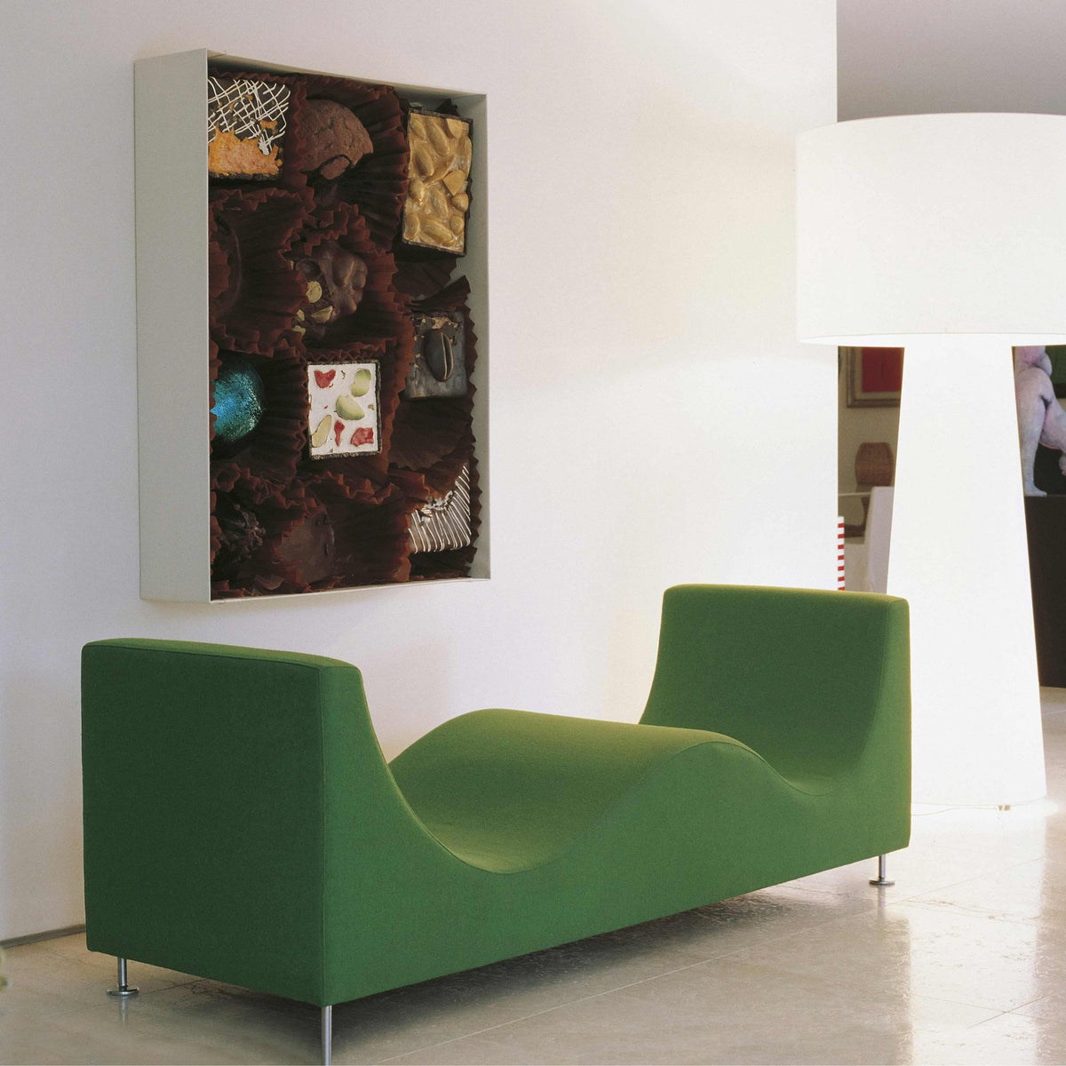 Cappellini Three Sofa de Luxe by Jasper Morrison. A vibrant green modern seating piece sits beneath contemporary wall art.